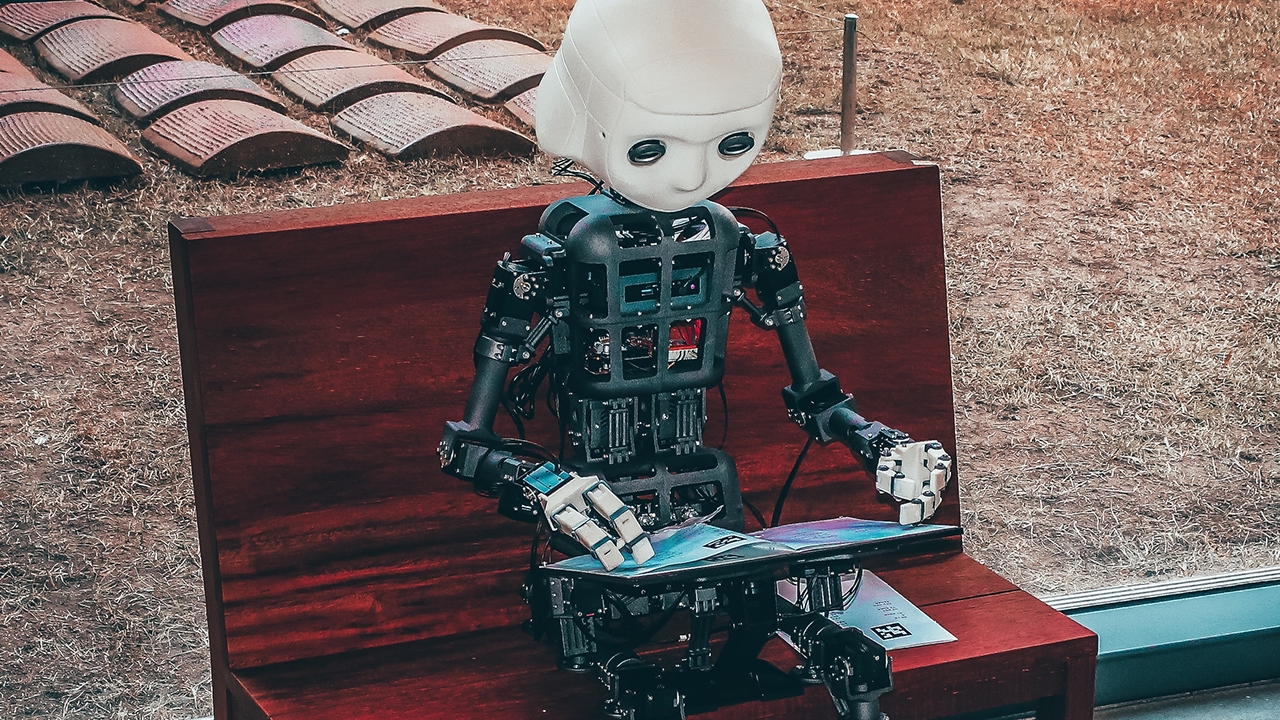 Little Robot sitting on a red bench testing the UI of an Adobe Commerce Storefront